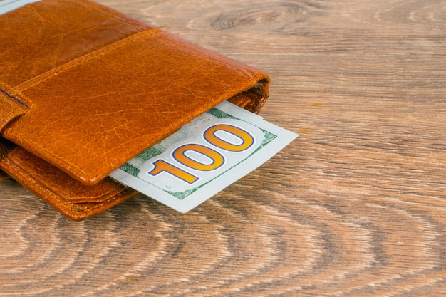 Photo wallet with dollar banknotes on table