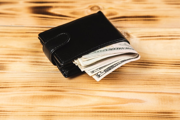 Photo wallet with money on wooden surface