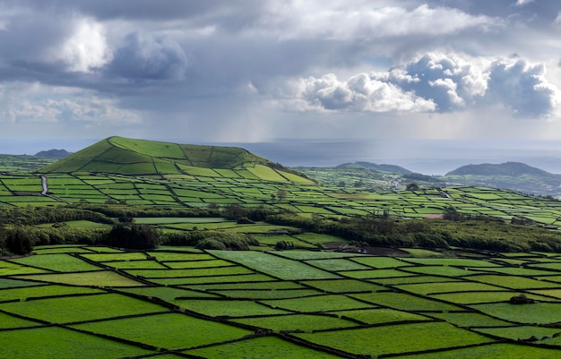 Wallpaper groene velden wolken en vulkaan in terceira eiland azoren