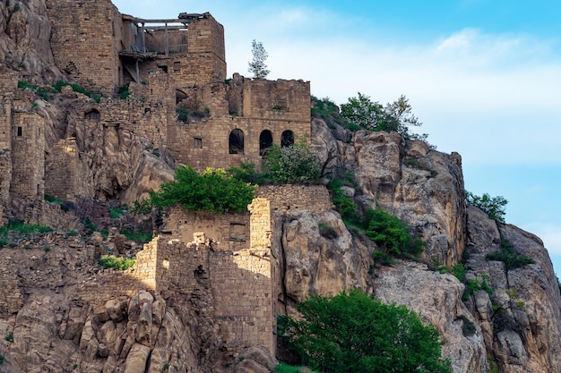 Walls of abandoned houses on a mountain cliff in the ghost village of Gamsutl in Dagestan