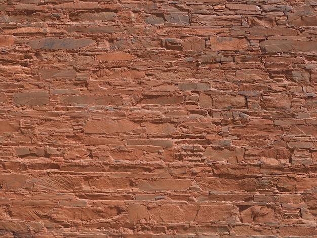 The walls are made of stone, mixed with orange soil.     