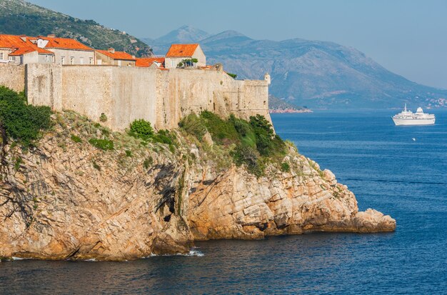 Walls of famous Dubrovnik Old Town (Croatia) and white ship.