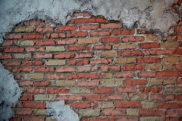 Walls of old red brick The wall texture With pieces smeared putty Showered