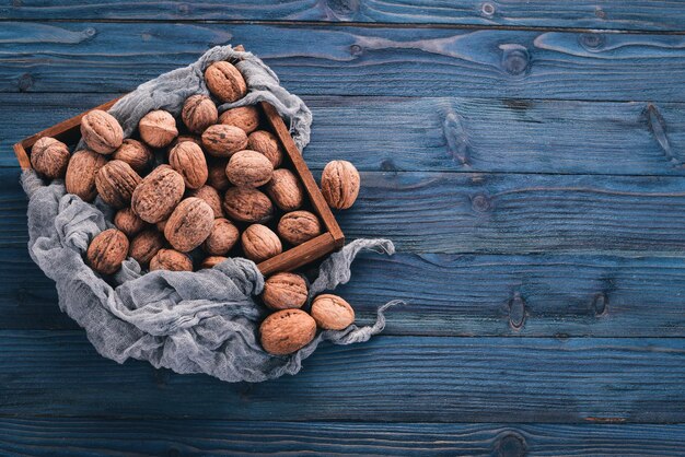 Walnut. In a box on a wooden background. Top view. Copy space.