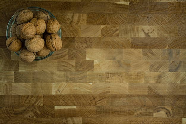 Walnut in a glass bowl on a wooden background.