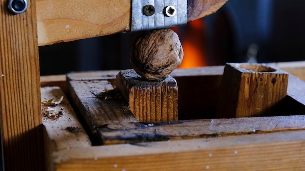 Photo walnut in a handmade nutcracker next to the fireplace in autumn