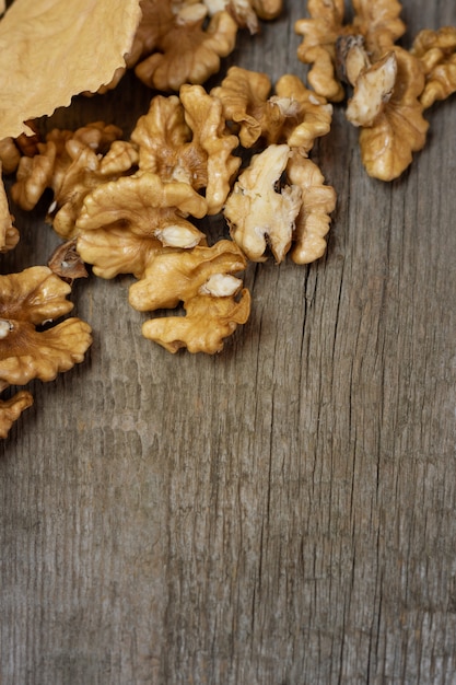 Walnut kernels on dark wooden with gold leaves.