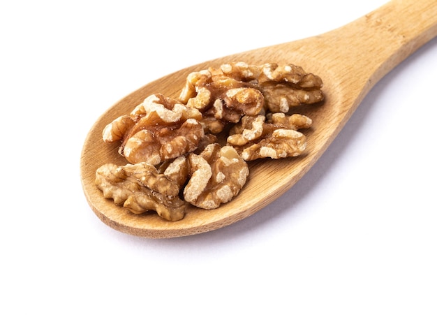 Walnut kernels on a spoon isolated over white background