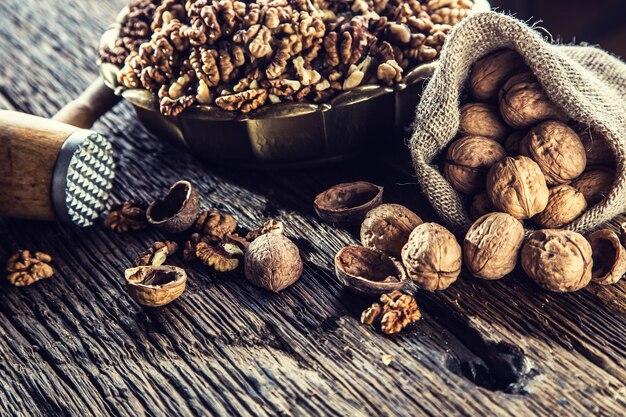 Walnut kernels whole walnuts in burlap sack and vintage bowl.