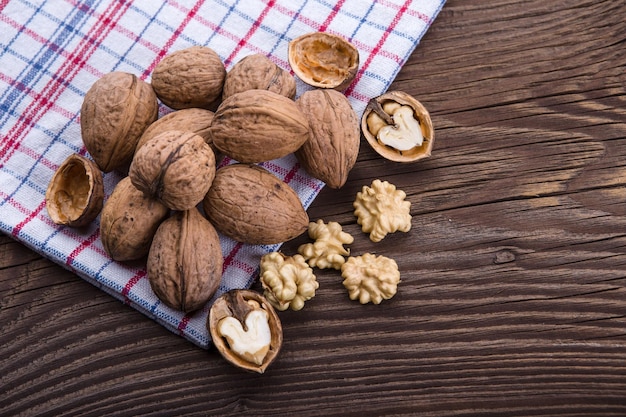 Walnut kernels and whole walnuts on old wooden table