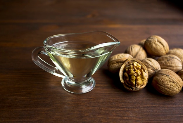 Foto noci di noce e olio di noce su sfondo in legno con texture spazio di copia superfood vegano cibo vegetariano concetto spuntino sano