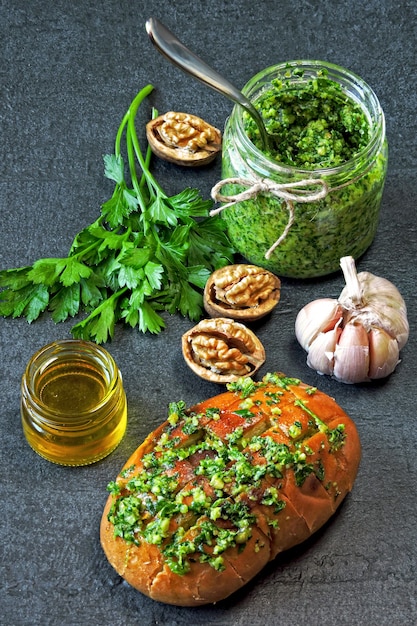 Salsa al pesto di prezzemolo di noci in un barattolo. panino caldo con pesto.