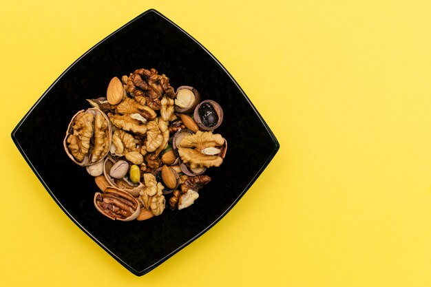 Walnut,pistachios,pecan and almond in the black square plate. Concept of healthy food.