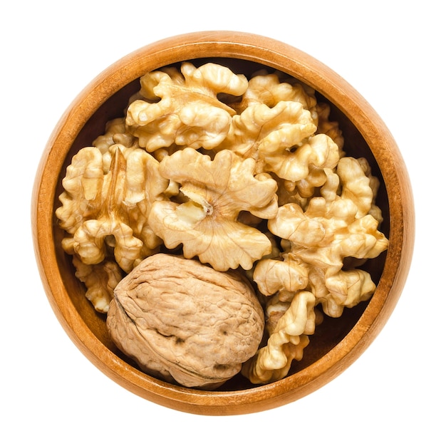 Walnut and shelled walnut kernel halves in wooden bowl