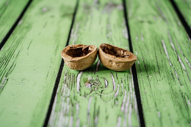 Walnut shells on green wooden boards