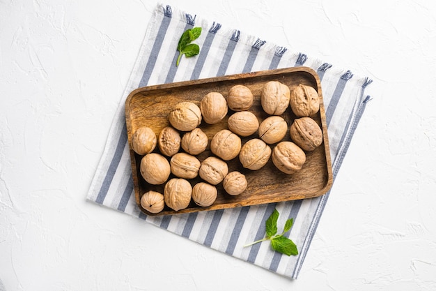 Walnut whole nut set on white stone table background top view flat lay