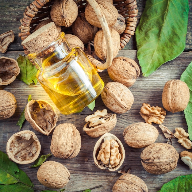 Walnuts bottle of nut oil and basket on old table