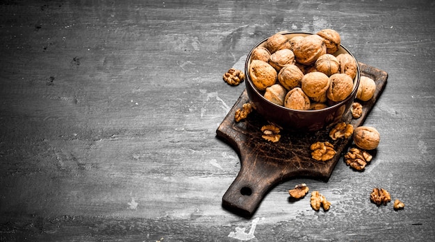 Walnuts in a bowl on black chalkboard