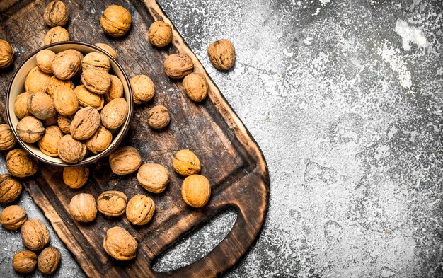 Walnuts in a bowl on rustic table.