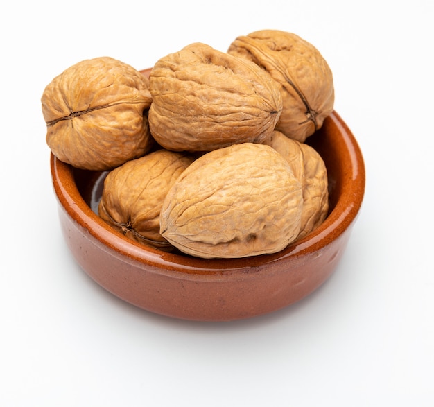 Walnuts in clay bowl (Various nuts collection). Isolated