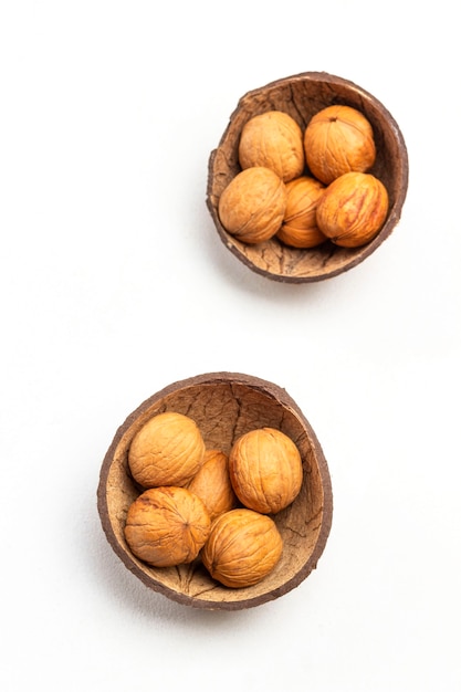 Walnuts in coconut shell. white background. flat lay