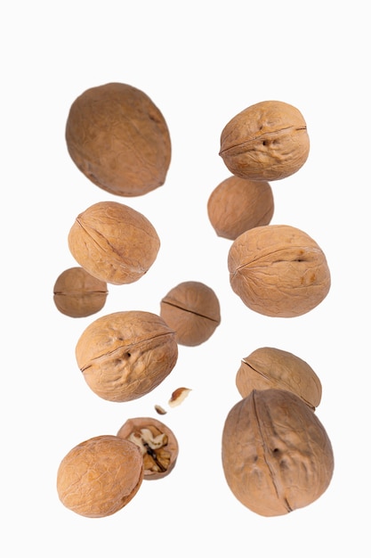 Photo walnuts fly over white background