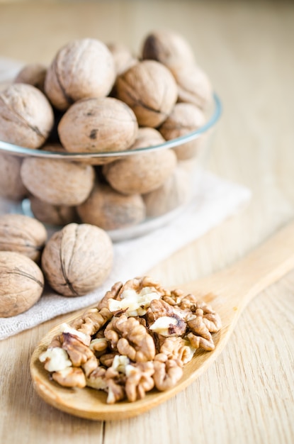 Walnuts in glass bowl and wooden spoon