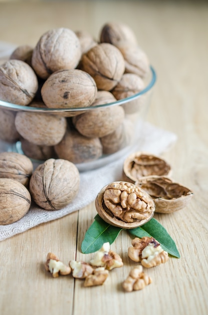 Walnuts on a glass bowl on wooden table