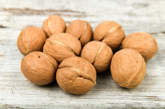 Noci nelle mani. primo piano vista di noci nella sua palma. le noci sono 4 acqua, 15 proteine, 65 grassi e 14 carboidrati, tra cui 7 fibre alimentari. in una porzione di riferimento di 100 grammi.