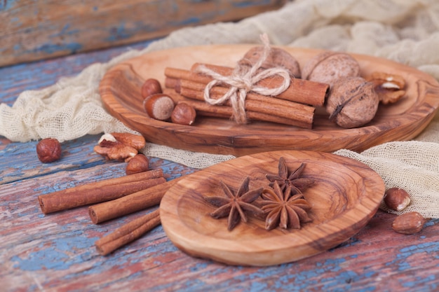 Арахис и грецкие орехи с корицей в деревянных тарелках