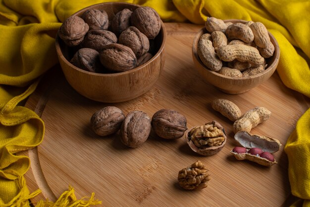 Noccioli di noci su sfondo scuro, noci in ciotola di legno di bambù