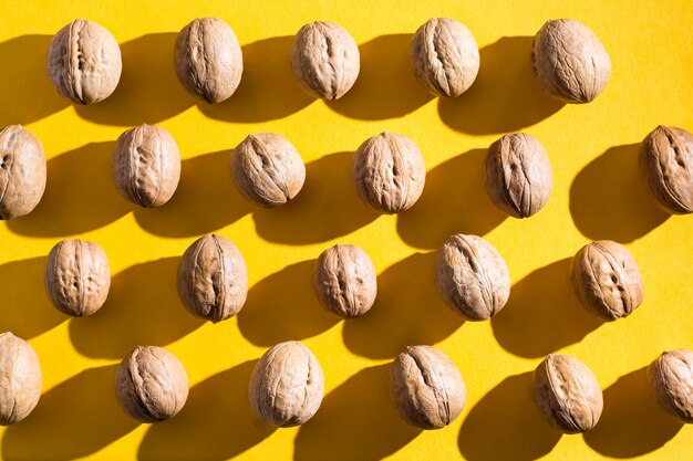 Walnuts lie in rows on yellow cardboard