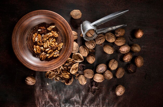 Walnuts and metal nutcracker on a wooden background