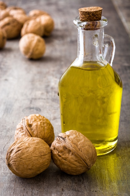 Foto olio di noci in barattolo sulla tavola di legno