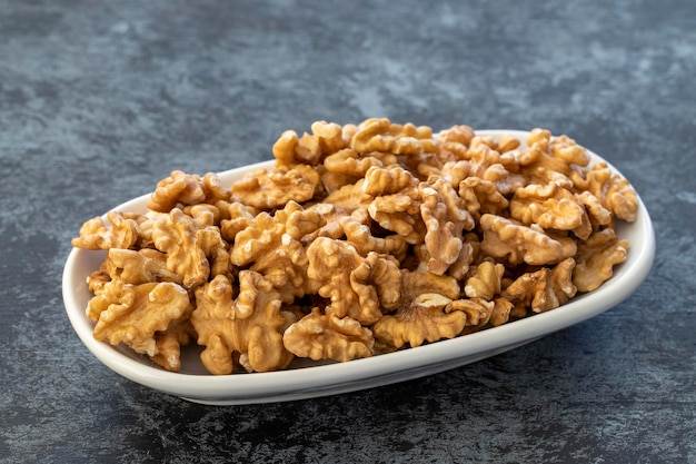 Walnuts on plate on dark background