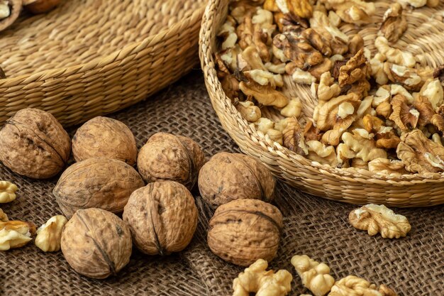 Walnuts on rustic natural burlap Walnut kernels in wicker basket Walnut background