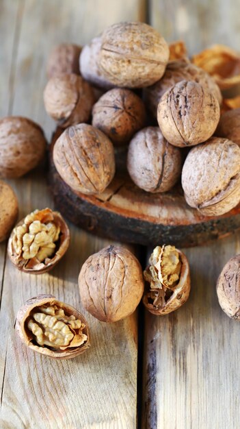 Walnuts in shells on a wooden surface.