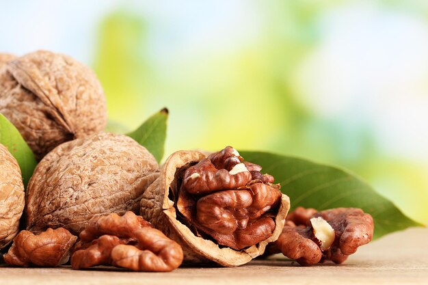 Walnuts with green leaves on green background