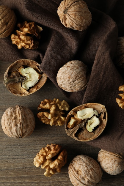 Walnuts with kitchen towel on wooden background