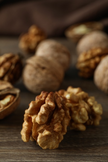 Photo walnuts with kitchen towel on wooden background