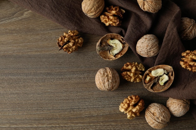 Walnuts with kitchen towel on wooden background