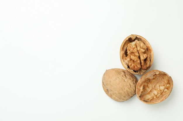 Walnuts with nutshell on white background, close up