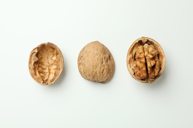 Walnuts with nutshell on white background, close up