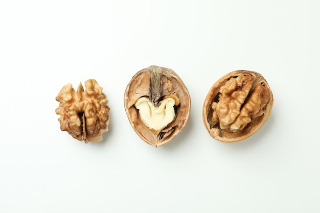 Walnuts with nutshell on white background, top view