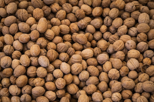 Walnuts with shell on a display case in a supermarket.