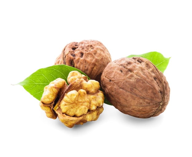 Walnuts with shell and green leaf isolated