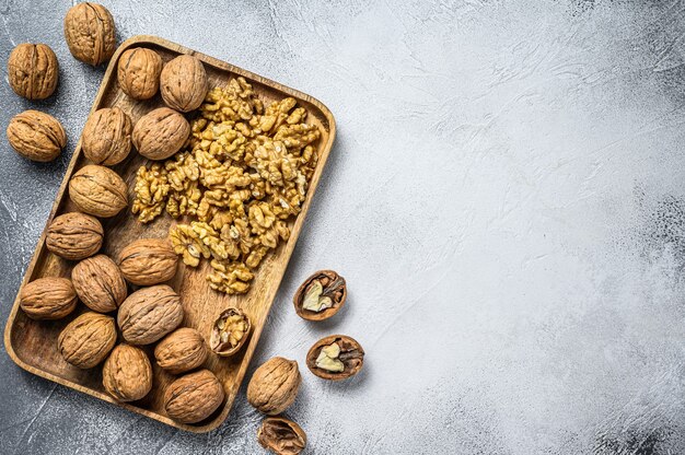 Walnuts in a wooden plate and walnut kernels