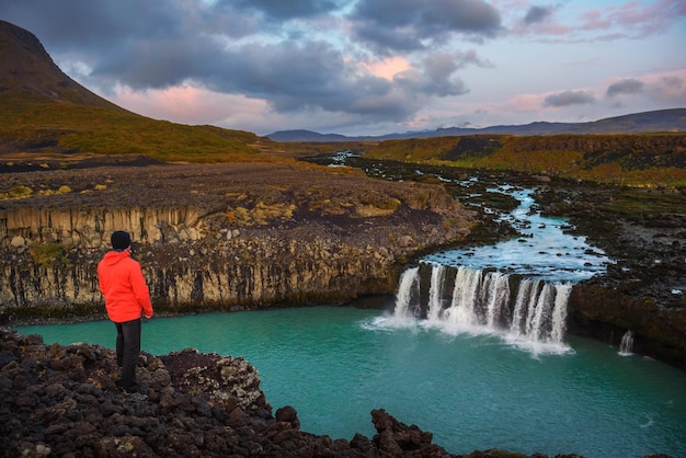 Wandelaar aan de rand van de thjofafoss-waterval in ijsland