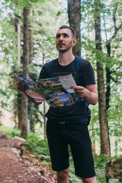 Wandelaar die een kaart gebruikt om de bestemming in het bos te lokaliseren