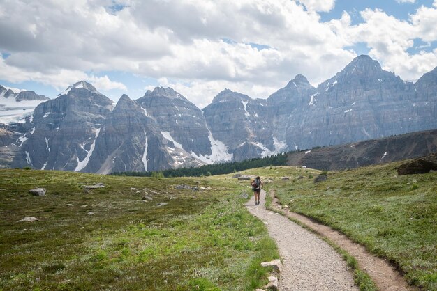 Wandelaar die het pad afloopt, omringd door bergen in de alpiene vallei, canadese rockies canada